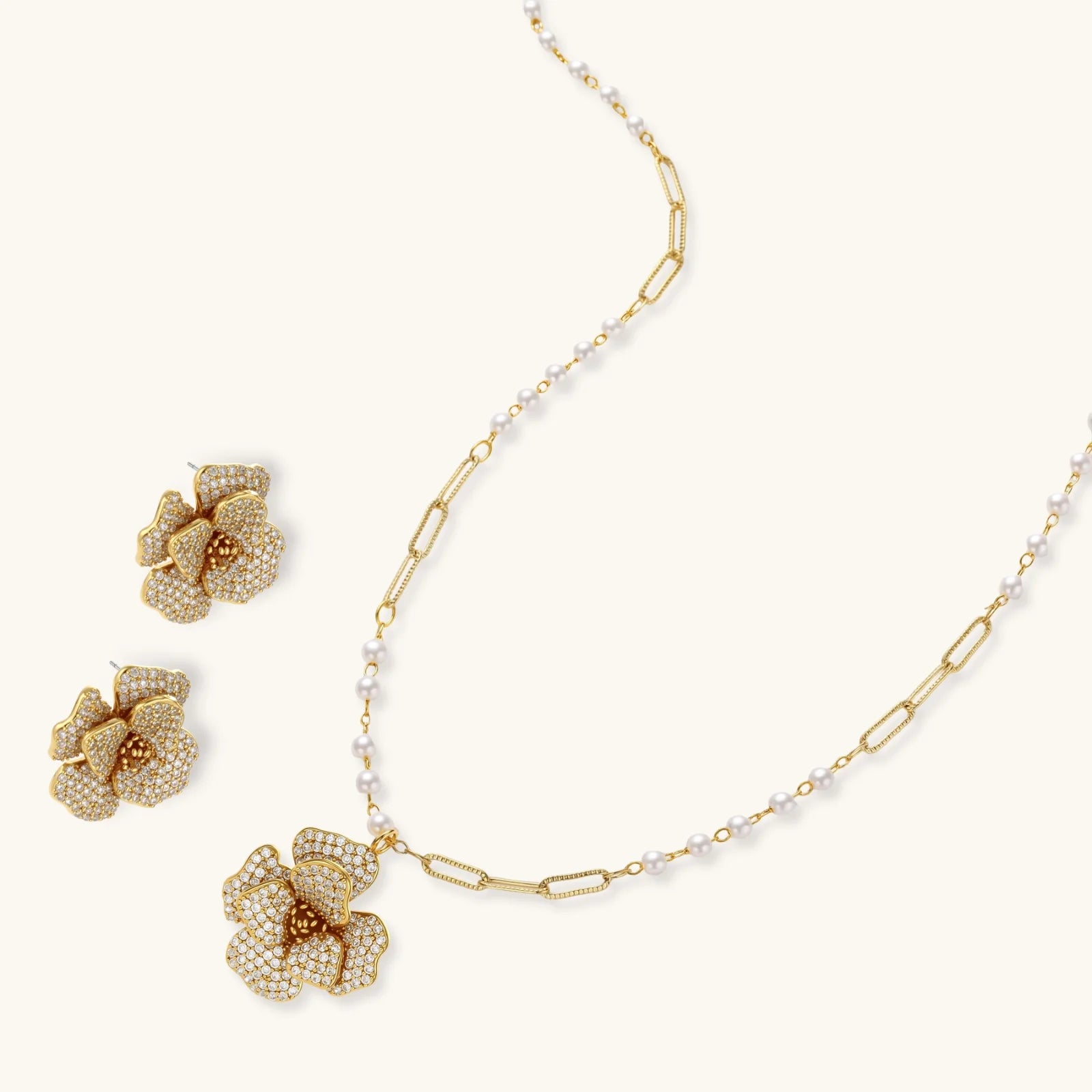 14K gold-plated floral jewelry set with blue cubic zirconia centers and pearl chain details on white background.